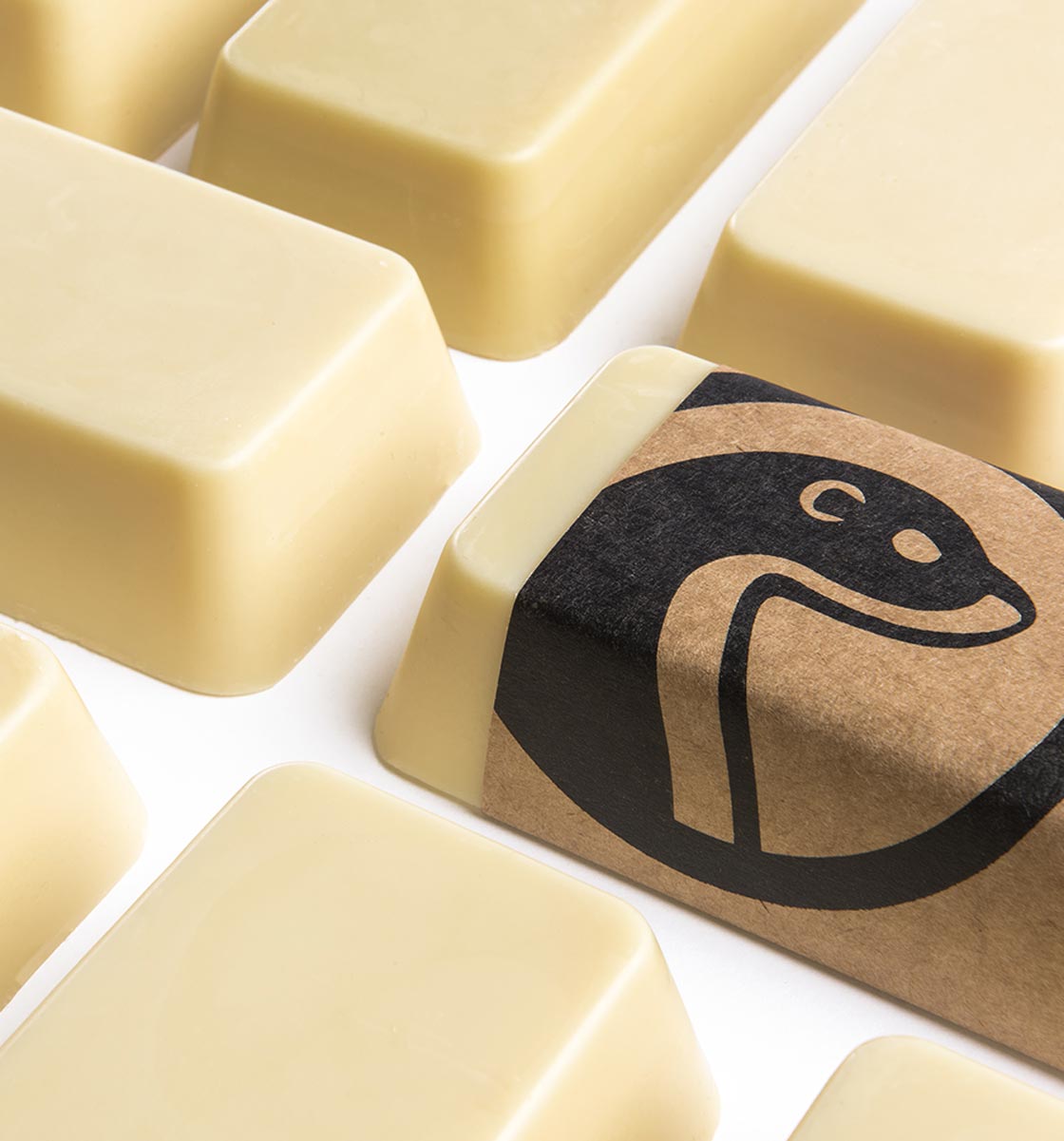 Close-up of Otter Wax canvas and fabric wax bars used for natural waterproofing, with product packaging showing the otter logo