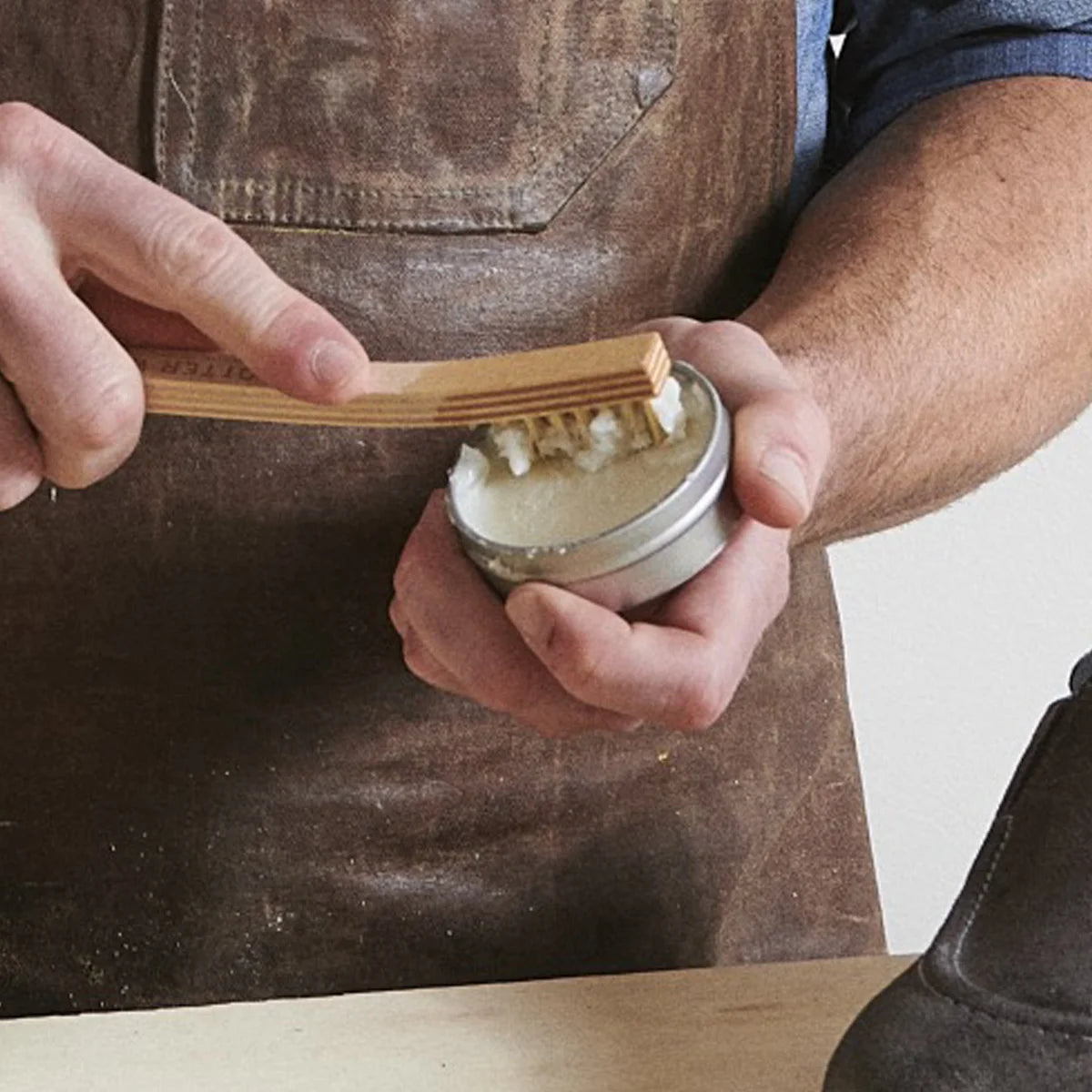 Close-up of brush working Otter Wax Saddle Soap into lather on suede leather shoe