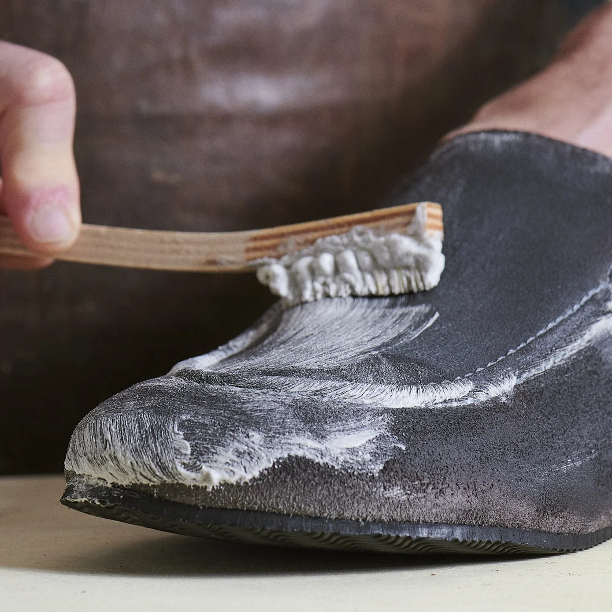 Close-up of brush working Otter Wax Saddle Soap into lather on suede leather shoe