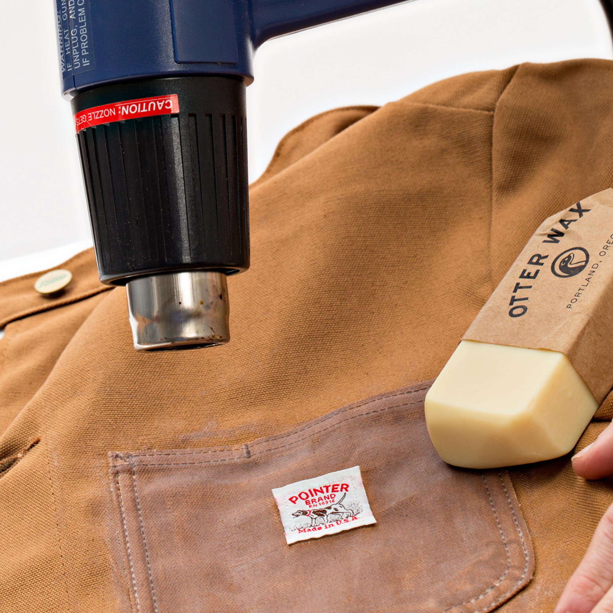heat gun being used to help spread otter wax fabric wax onto pointer brand chore coat