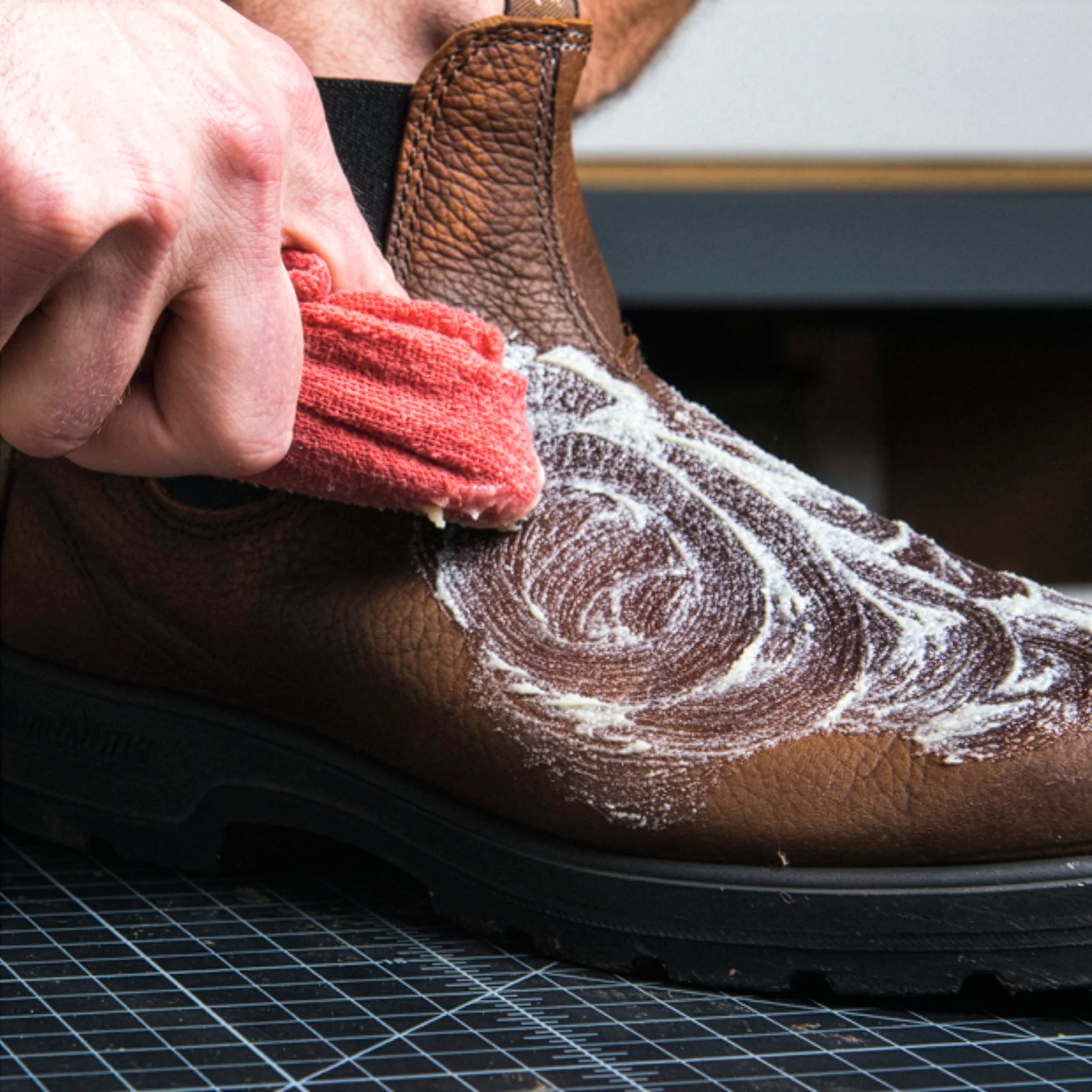 otter wax leather salve being applied to leather boot