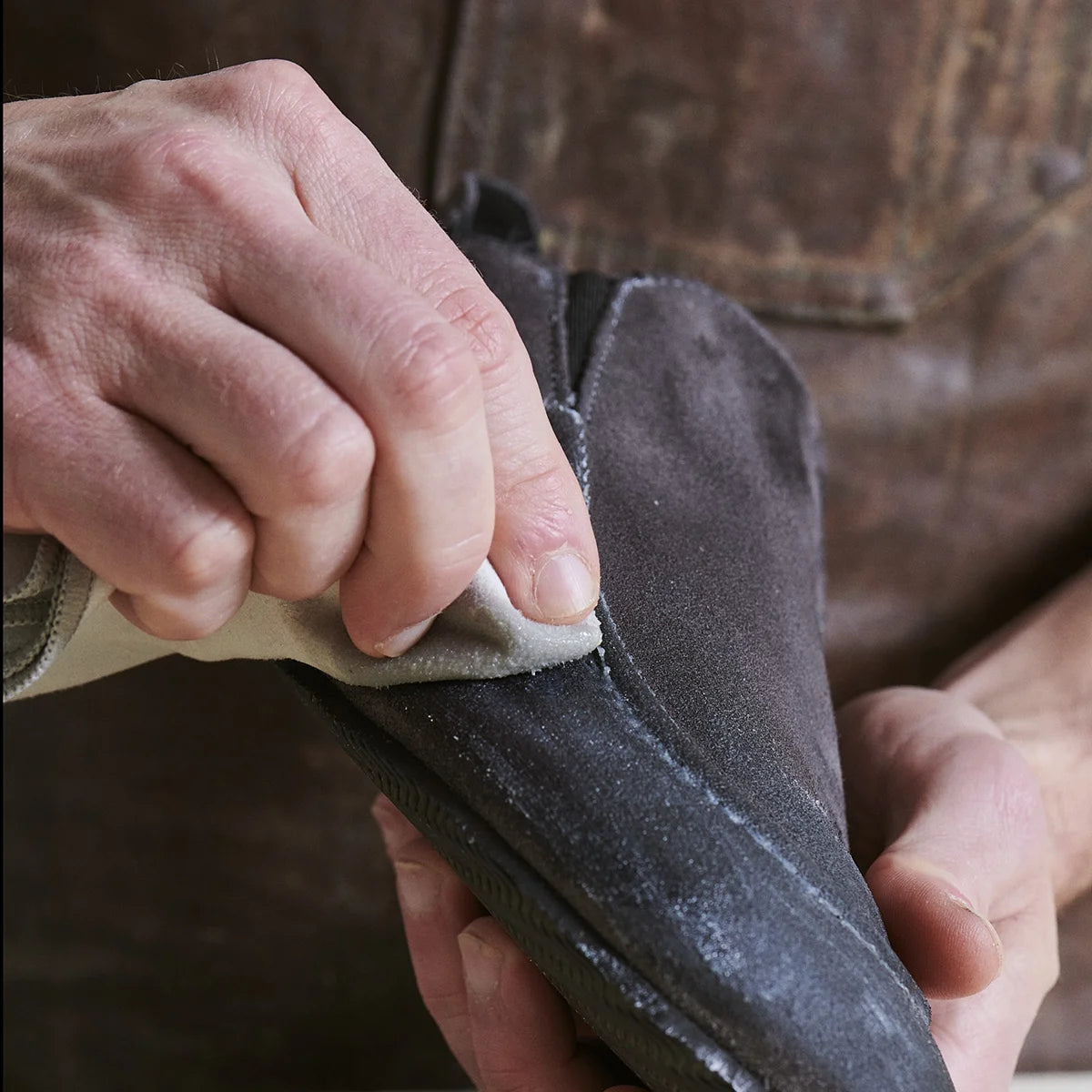 hands removing otter wax saddle soap from the surface of clean leather