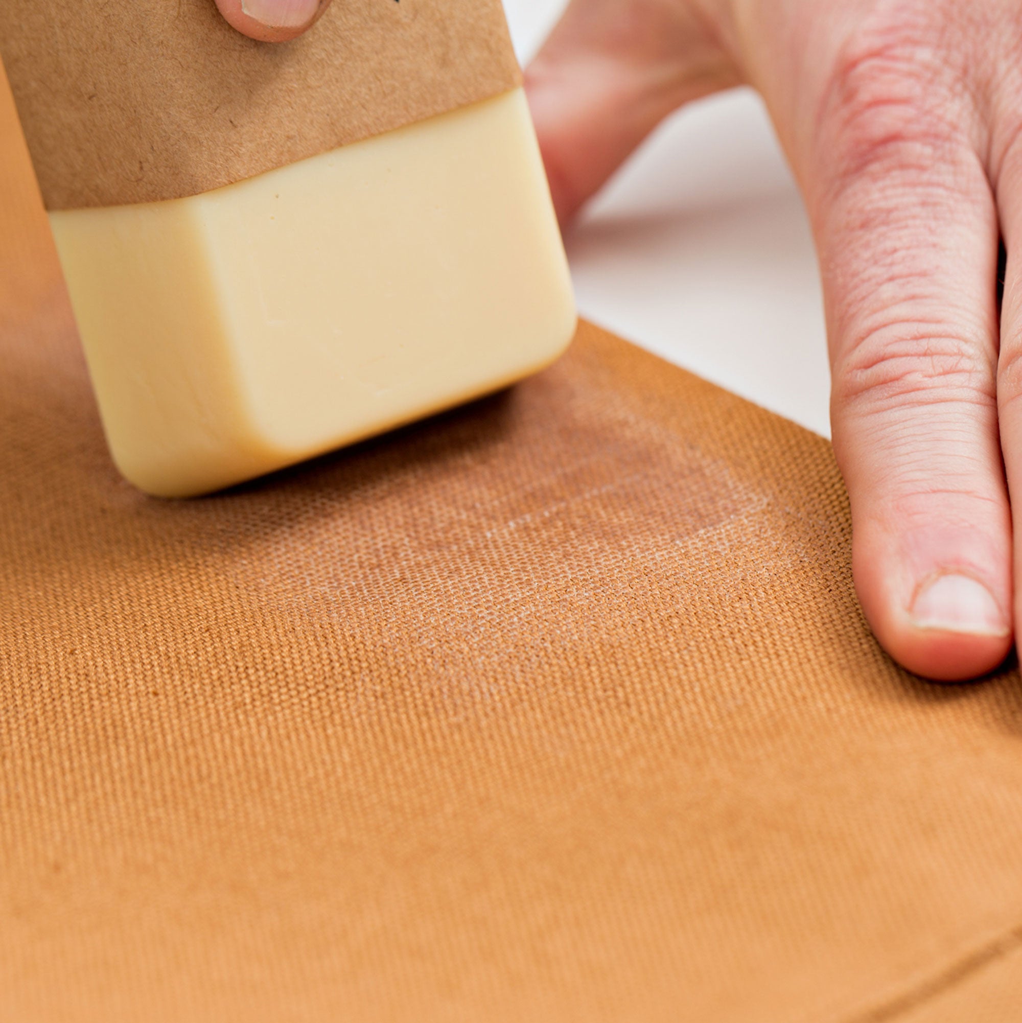 otter wax bar being used to waterproof pointer brand chore coat