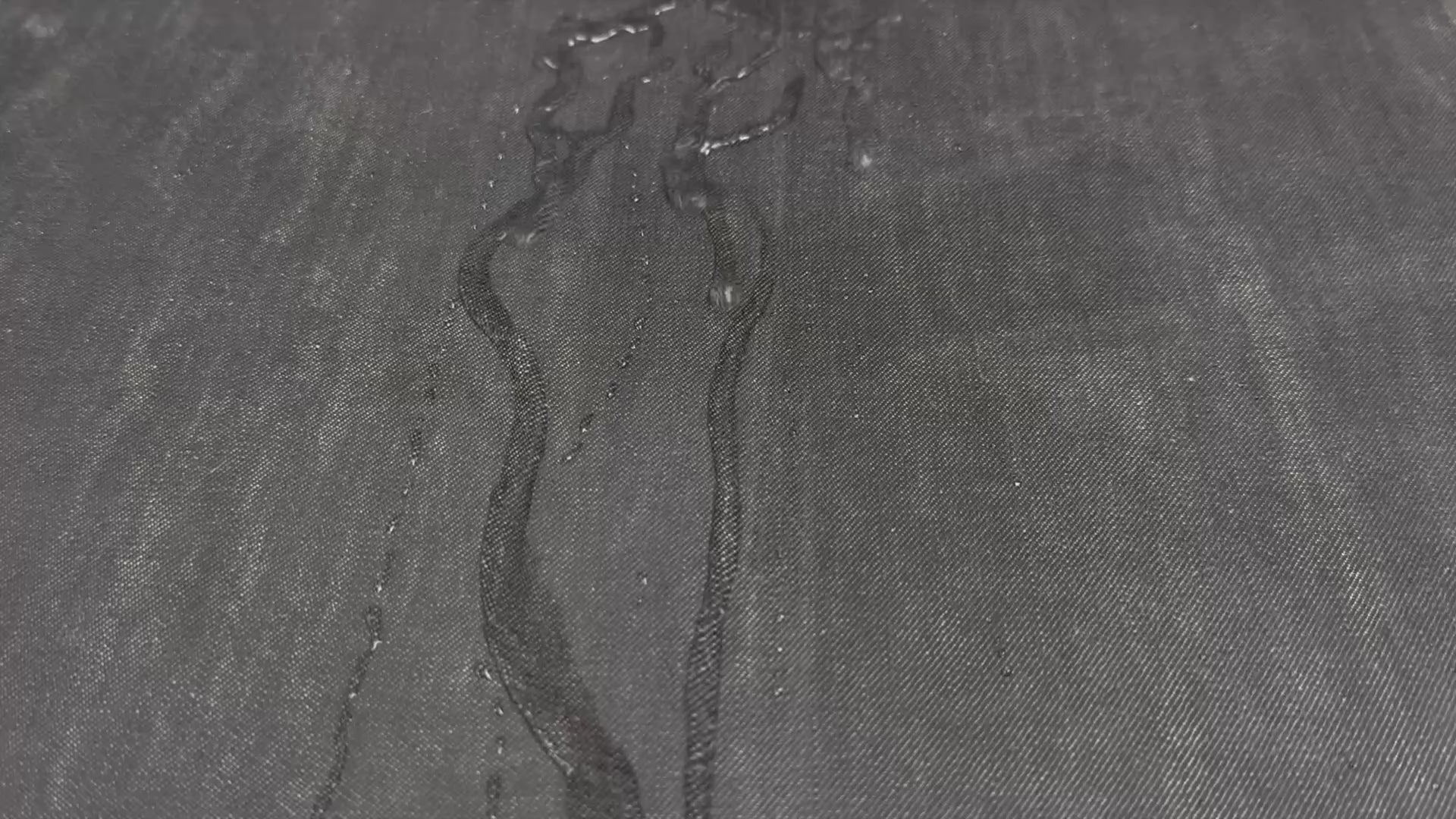 water flowing down waxed canvas treated with otter wax